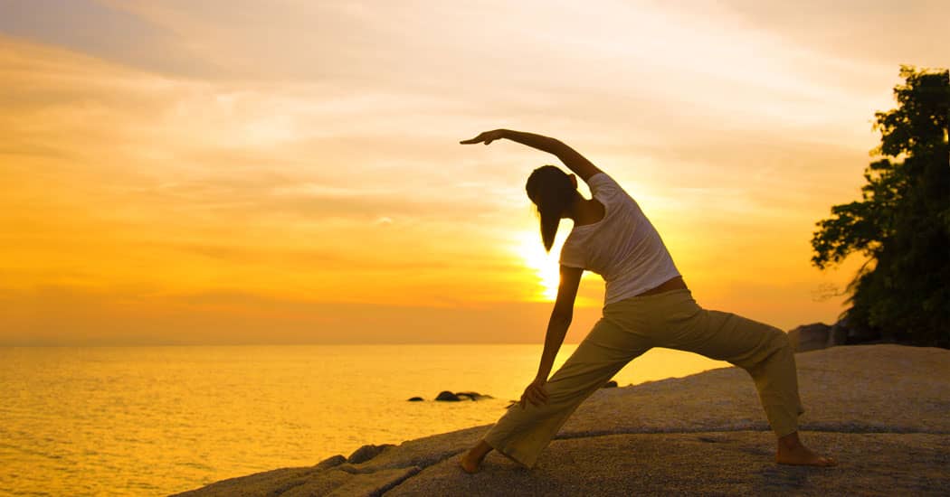 Lady doing yoga on the beach